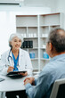 © Nuttapong punna - Senior man being examined by a doctor sitting at the table. Medicine and health care concept.