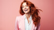 Happy businesswoman with red hair on a solid colored background