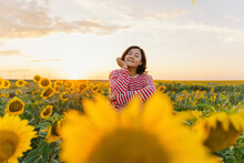 Mature Woman Amidst Sunflowers In Field