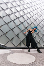 Young Dancer With Dyed Blue Hair Dancing Near Modern Building