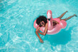 © VISTA by Westend61 - Smiling young woman swimming with inflatable ring