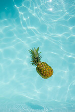 Pineapple Floating On Water In Swimming Pool