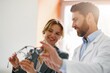© Friends Stock - The ophthalmologist helps the client to choose a more suitable spectacle frame