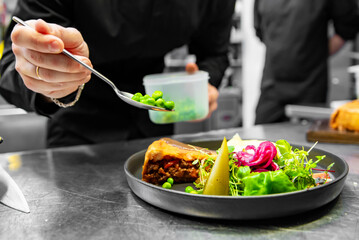 chef hand preparing Meat Pie with mashed potato and salad on restaurant kitchen