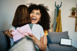 © aLListar/peopleimages.com - Excited, hug and present for birthday of girl friends and smile on living room sofa. Surprise, gift and happy female person at home with giving in lounge with celebration, congratulations and package