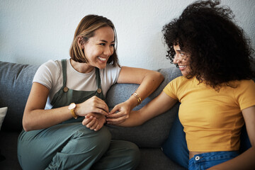 Canvas Print - Conversation, happy and lesbian couple relaxing on a sofa in the living room talking and bonding. Love, communication and young interracial lgbtq women speaking and resting together in lounge at home