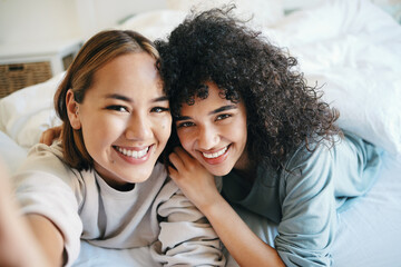 Sticker - Smile, selfie and portrait of lesbian couple on bed for bonding, resting or relaxing together. Happy, love and young interracial lgbtq women taking picture in the bedroom of modern apartment or home.