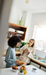 © aLListar/peopleimages.com - Lesbian, women and couple with love, breakfast and romance with conversation, marriage and bonding. Lgbtq, girls and queer people in a kitchen, home and relationship with trust, speaking and support