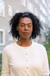 © Johnér - Mature woman looking at camera, block of flats in background