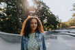 © Johnér - Smiling teenage girl looking at skate park looking at camera