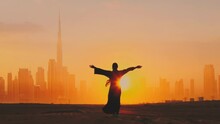 Arab Woman Rises Her Hands On Dubai City Silhouette With Sunset