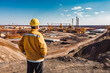 © VisualProduction - Mining engineer at mine site. Portrait of male engineer with hardhat using digital tablet while working at construction site