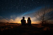 Silhouettes of a young couple admiring beautiful view on sunset. Man and woman looking at scenic night landscape. Lovers stargazing.