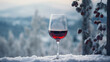 Wine glass filled with red wine placed in the snow outdoors during winter