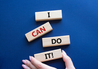 I can do it symbol. Concept words I can do it on wooden blocks. Beautiful deep blue background. Businessman hand. Business and I can do it concept. Copy space.