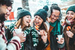 © Davide Angelini - Happy friends having fun drinking mulled wine and hot chocolate at Christmas Market - Cheerful young people enjoying winter holidays on weekend vacation - Tourism lifestyle and friendship concept