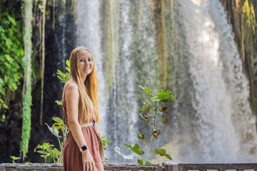 Wall Mural - Beautiful woman with long hair on the background of Duden waterfall in Antalya. Famous places of Turkey. Apper Duden Falls