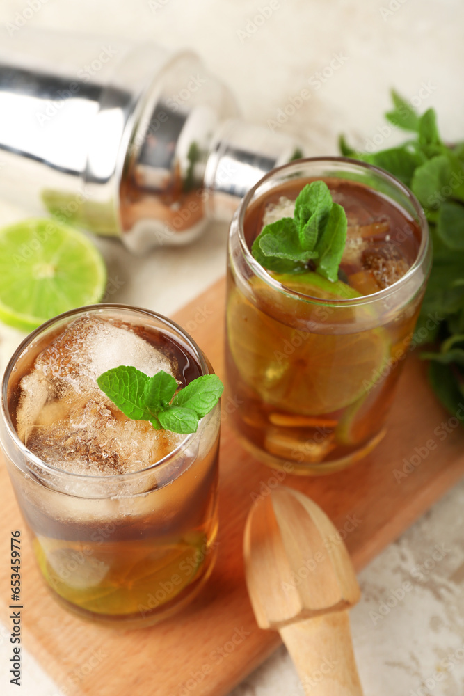 Glasses of tasty Cuba Libre cocktail on light background