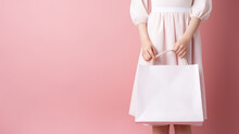 Close-up Of Female Hand Holding Blank White Shopping Paper Bag. Mockup Template For Branding Bag Isolated On Flat Pink Background With Copy Space.