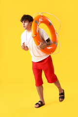 Sticker - Male lifeguard with ring buoy and whistle running on yellow background