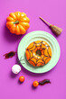 Leinwandbild Motiv Plate of tasty donut with decorations for Halloween on purple background