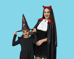 Sticker - Little girl with her mother dressed for Halloween on blue background