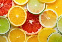 A Veritable Rainbow Of Colors Comes To Life In This Shot, Showcasing Slices Of Various Citrus Fruits Beautifully Arranged In A Wheellike Pattern. The Invigorating Scent Of Oranges, Lemons,