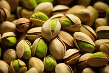 A Topdown Shot Captures The Natural Elegance Of Raw Pistachios, Their Vibrant Green Shells Peeking Through A Tering Of Split Husks, Inviting The Viewer To Crack Them Open.