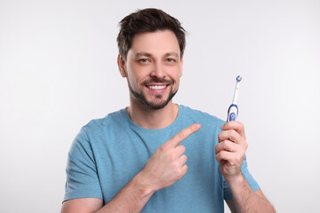 Wall Mural - Happy man holding plastic toothbrush on white background. Mouth hygiene