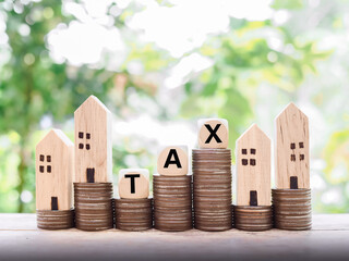 Poster - Miniature house, wooden blocks with the word TAX and stack of coins. The concept of paying tax for house and property.