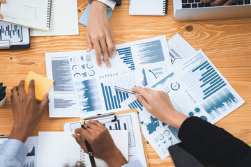 Flat top view workspace wooden table with analyst team use BI dashboard papers data for planning business strategy. Businesspeople utilize data analysis by FIntech for marketing indication. Concord