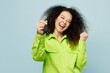 © ViDi Studio - Young happy latin woman she wear green shirt casual clothes hold car keys fob keyless system do winner gesture isolated on plain pastel light blue cyan background studio portrait. Lifestyle concept.