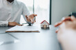 © Jirapong - Guarantee, mortgage, agreement, contract, signed, real estate agent pointing to documents for customers to read the agreement before signing important documents