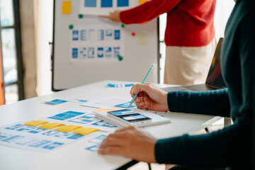 Close up view of UI developer team brainstorming on their project with laptop, smartphone and digital tablet. Creative digital development agency.