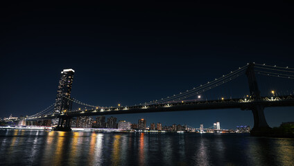 Wall Mural - New York skyline by night. Landscape photo during the evening, view to Brooklyn and Manhattan bridge and landmark skyscraper office buildings from New York, America.