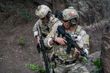 Military army soldiers tactical team, commando group moving cautiously in forest area, kneeling and looking around, covering comrades, controlling sectors. Commander showing halt or stop hand signal