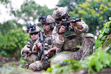 Military army soldiers tactical team, commando group moving cautiously in forest area, kneeling and looking around, covering comrades, controlling sectors. Commander showing halt or stop hand signal