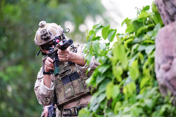 Wall Mural - Military army soldiers tactical team, commando group moving cautiously in forest area, kneeling and looking around, covering comrades, controlling sectors. Commander showing halt or stop hand signal