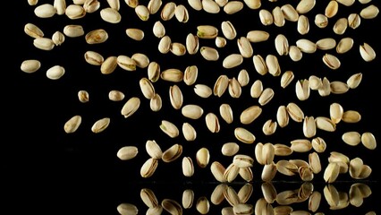 Poster - Super Slow Motion of Falling Pistachio Nuts with Reflection. Isolated on Black Background. Filmed on High Speed Cinema Camera, 1000fps.