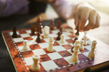 Hands, chess game and board with strategy in competition or challenge, intelligence and closeup of people playing. Thinking, planning and contest outdoor, concentration on boardgame and recreation