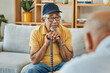 © aLListar/peopleimages.com - Doctor, consultation and senior man on sofa with walking stick or counselling discussion in therapy with psychologist. Elderly patent, talking and therapist listening on couch in mental health office