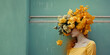 © ADDICTIVE STOCK - Generative AI illustration of unrecognizable woman with bright yellow colorful flower headpiece covering face leaning against blue wall background on the street