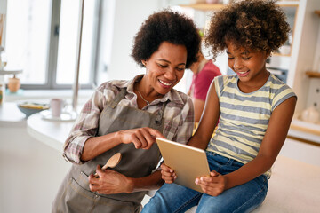 Wall Mural - Happy african american preeteen girl using digital tablet for education, fun at home. Family concept