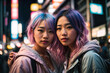  Pareja de chicas asiáticas de aspecto alternativo con pelo rosa/turquesa, en una calle  moderna de Tokio por la noche.