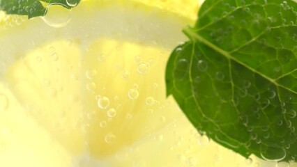 Wall Mural - Rotation of lemonade in a glass, macro. Fruit lemon cocktail close-up texture, healthy sweet drink. Detox drink, summer refreshment concept.