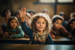 Elementary school student raises a hand in classroom. Concept of education.