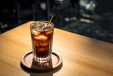 Americano coffee or iced coffee without milk in a tall glass with straw on the table.