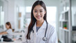 © Krisana - asian female Doctor Wearing White Coat With Stethoscope In Hospital Office.