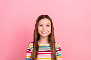 Wall Mural - Photo of cheerful little cute girl brown hair looking interesting interactive games app funny kid isolated on pink color background