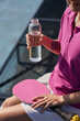 Pickleball player drinking water from a glass bottle